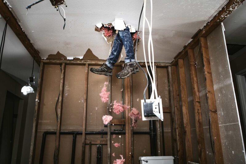 Picture Prompts: Demo Man A man's feet sticking through a hole in the ceiling beside trailing cords