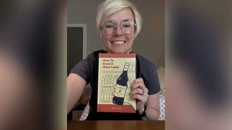 Marie Cheslik holding a copy of her book, How to Read a Wine Label.