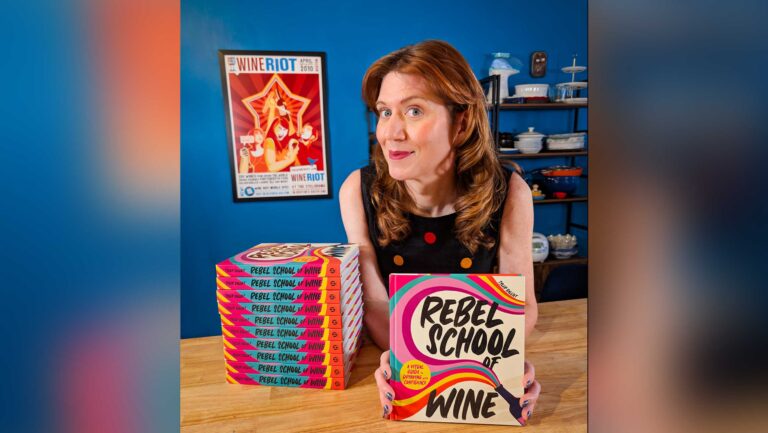 Tyler Balliet holding a copy of her book, Rebel School of Wine. 